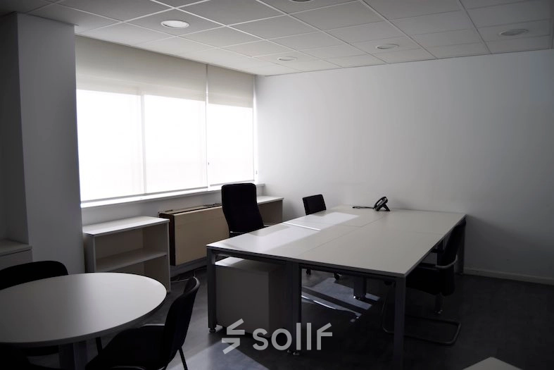 Modern, naturally-lit office to rent with sleek tables and chairs, suitable for professional workspaces in Madrid Center.