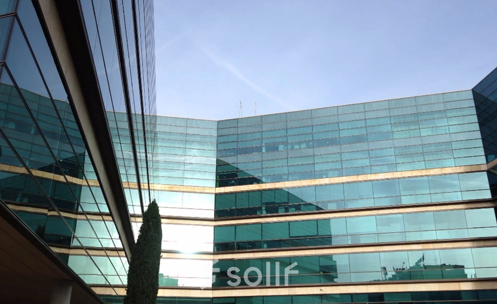 Modern glass office building with reflective surfaces in Madrid Hortaleza, ideal for office space rental.