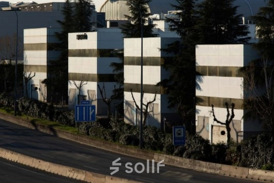 Exterior view of office buildings at Calle Ochandiano 6 in Madrid Moncloa with surrounding greenery.
