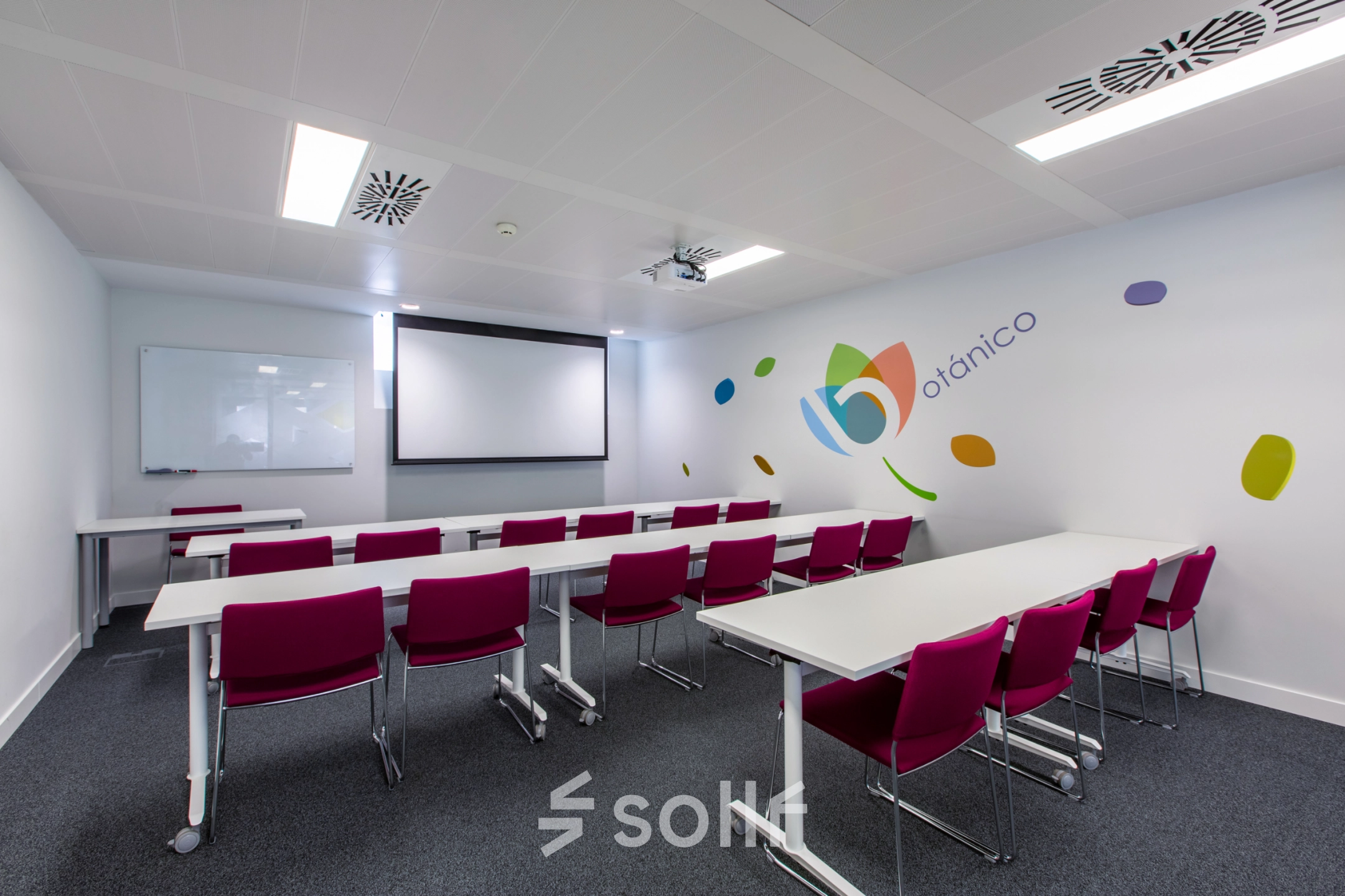 Office space rental in Madrid's Retiro district, featuring a conference room with modern furnishings and bright seating, perfect for professional meetings.