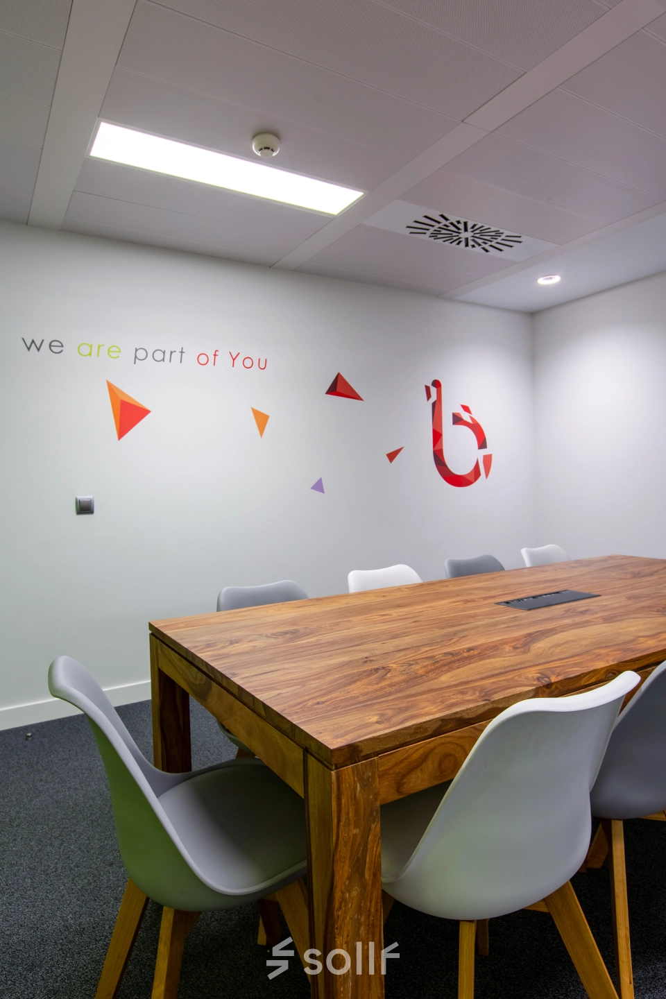 Interior office space in Madrid Retiro on calle de O'Donnell, featuring a modern conference room with a large wooden table and chairs, ideal for office to rent opportunities.