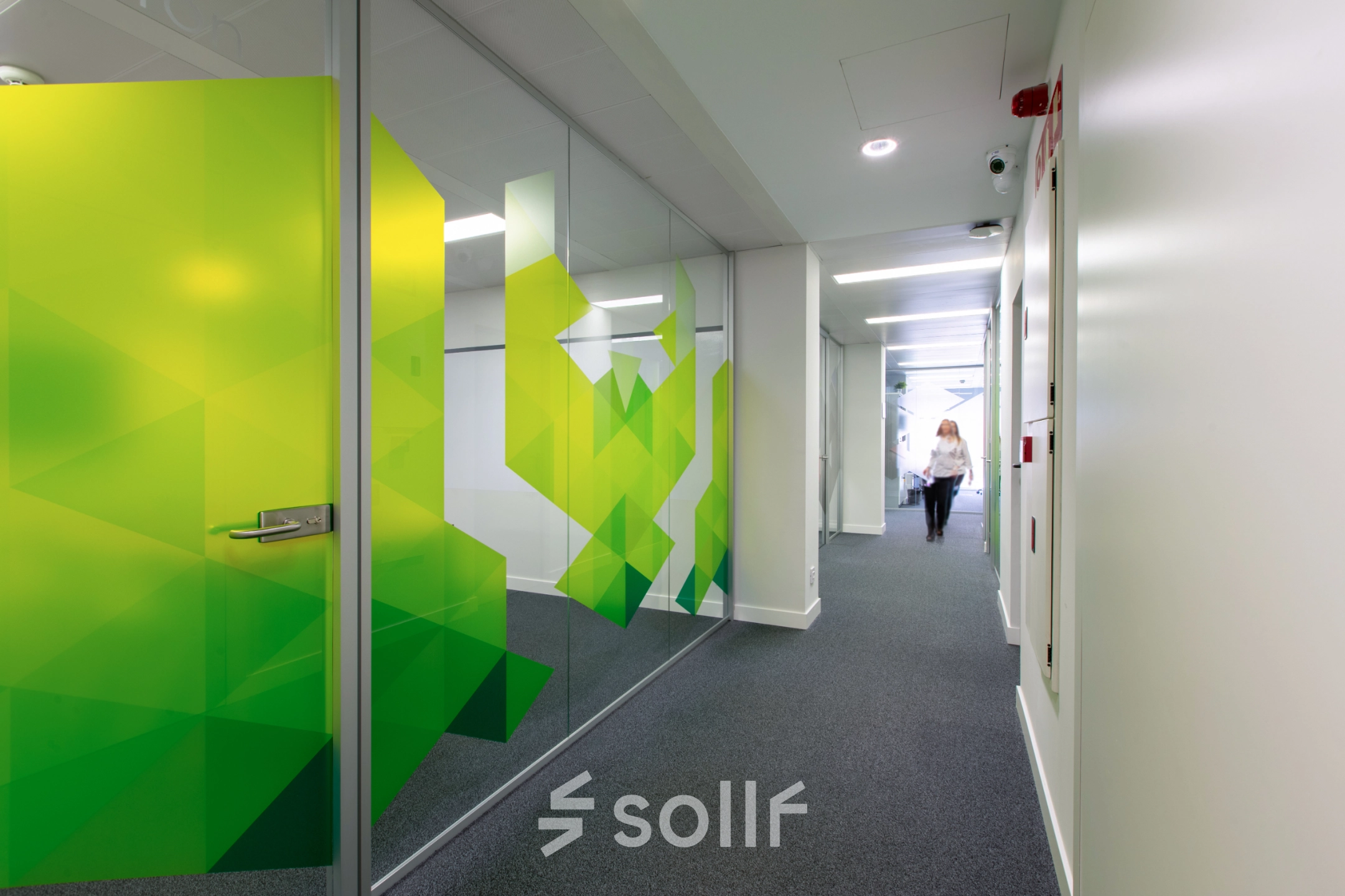 Hallway of an office at Calle de O'Donnell, Madrid Retiro with patterned glass walls, suitable for office space rental.
