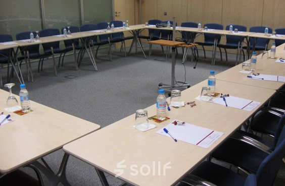 Office space rental at Avenida de Brasil 6, Madrid Tetuán with a conference room setup featuring tables, chairs, and water bottles arranged for a meeting.