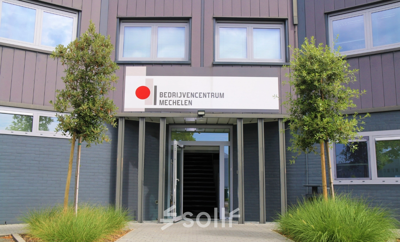 Exterior view of office space available to rent at De Regenboog 11, Mechelen North, featuring a modern facade with large windows.