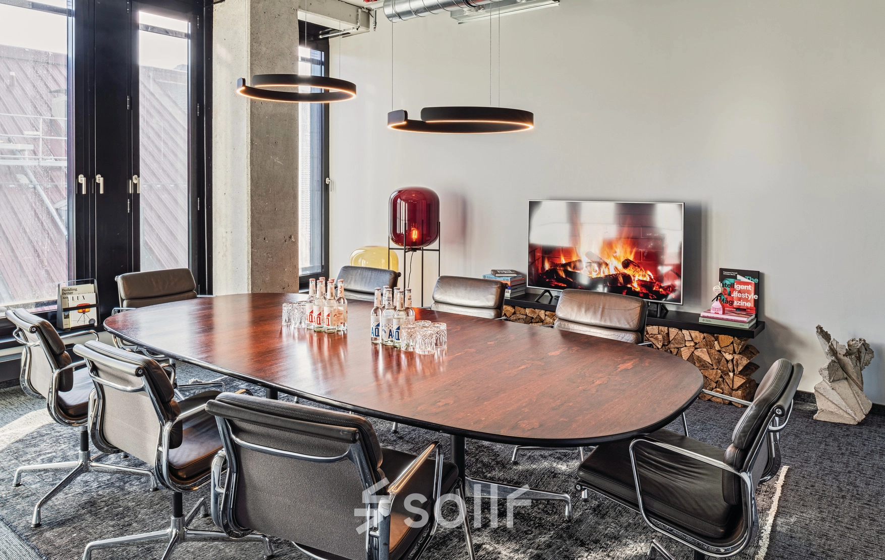 Modern conference room with a large wooden table surrounded by chairs at Rosenheimer Straße 143C. Ideal office space rental for meetings in München Werksviertel.