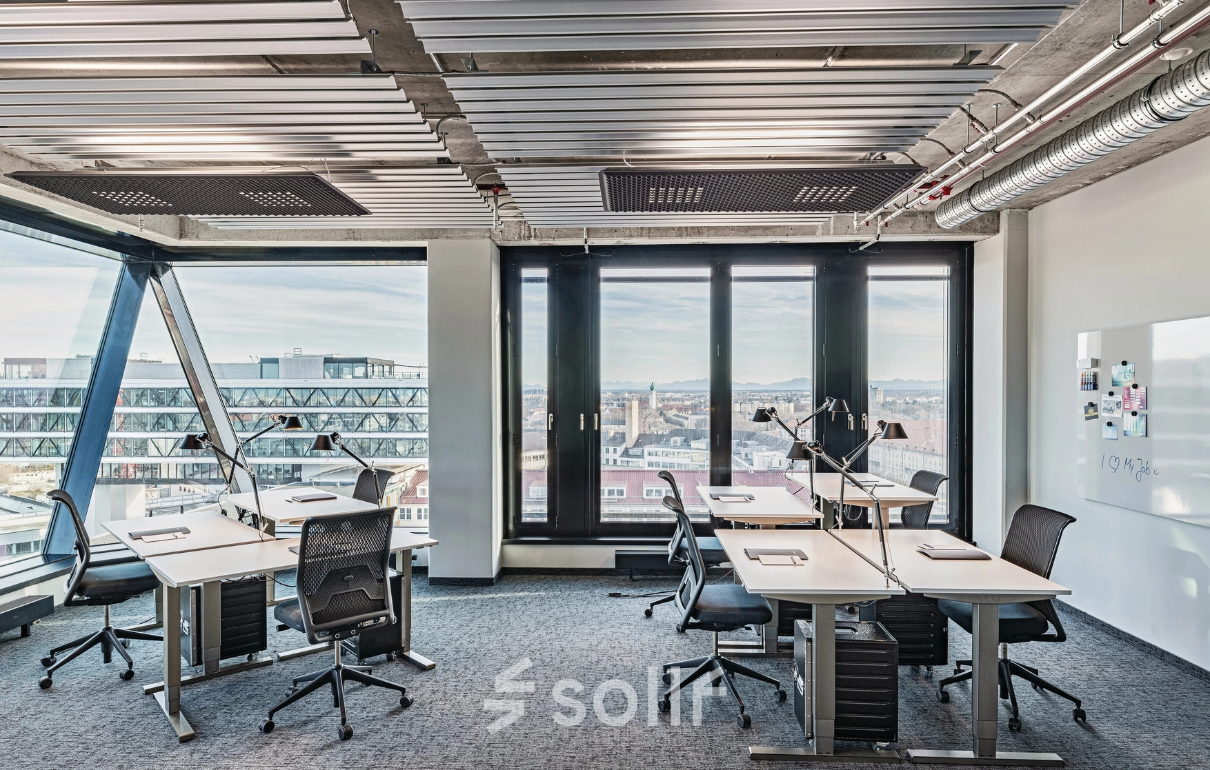 Modern office space with panoramic views at Rosenheimer Straße 143C, München Werksviertel, available for rent. The bright office features multiple desks and chairs, perfect for collaborative work.