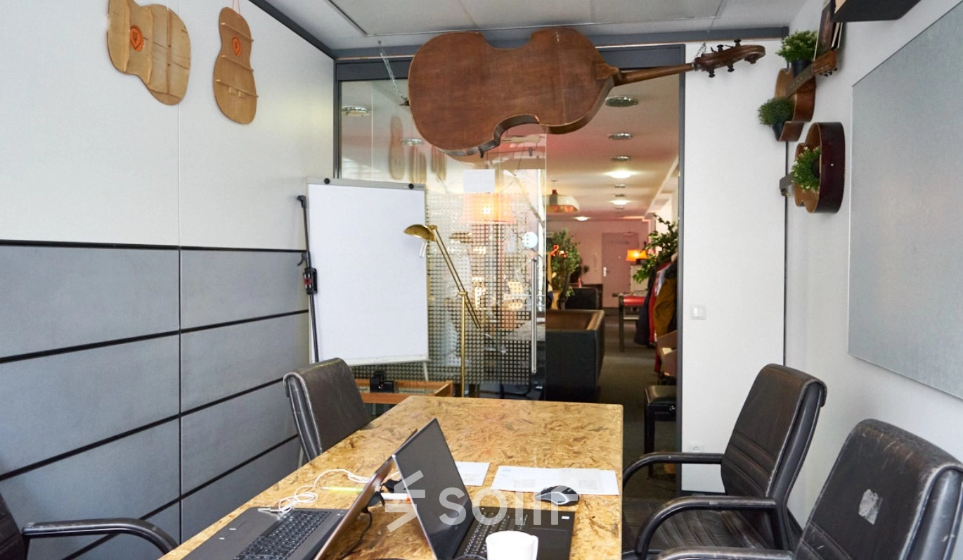 Furnished office space at Werinherstraße 3, Munich Giesing, featuring a table with laptops and a flipchart, ideal for office space rental.