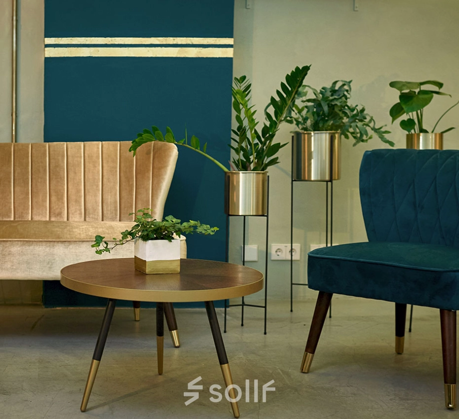 Stylish, furnished lounge area in an office to rent at Amalienstraße 71, Munich Maxvorstadt, featuring elegant seating and greenery.