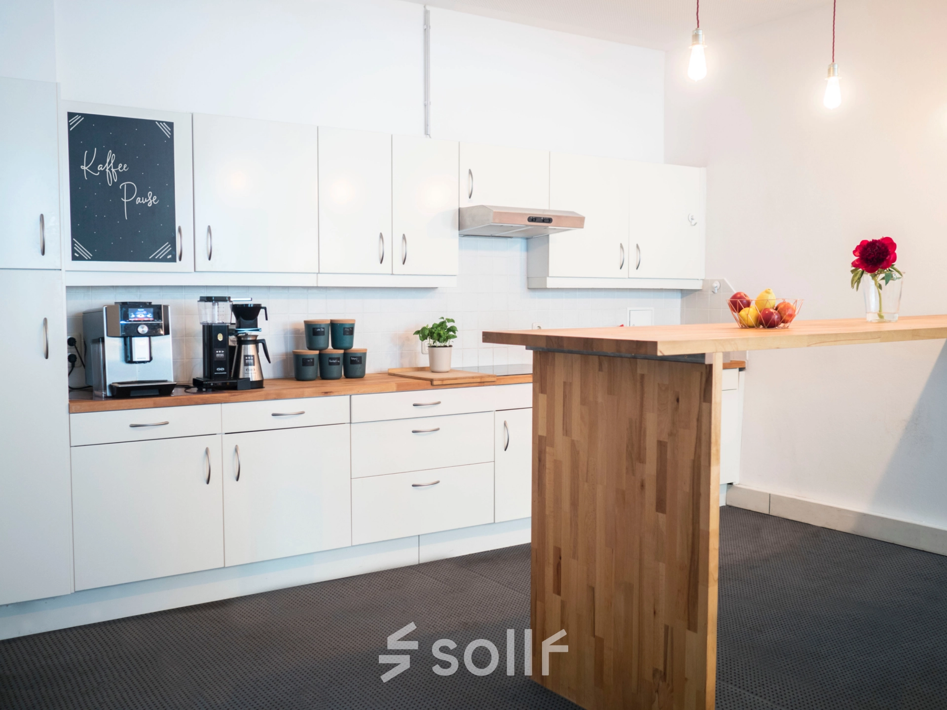 Modern furnished office kitchen area at Blütenstraße 15 in Munich Maxvorstadt, featuring a sleek design and equipped for efficient workspace needs.