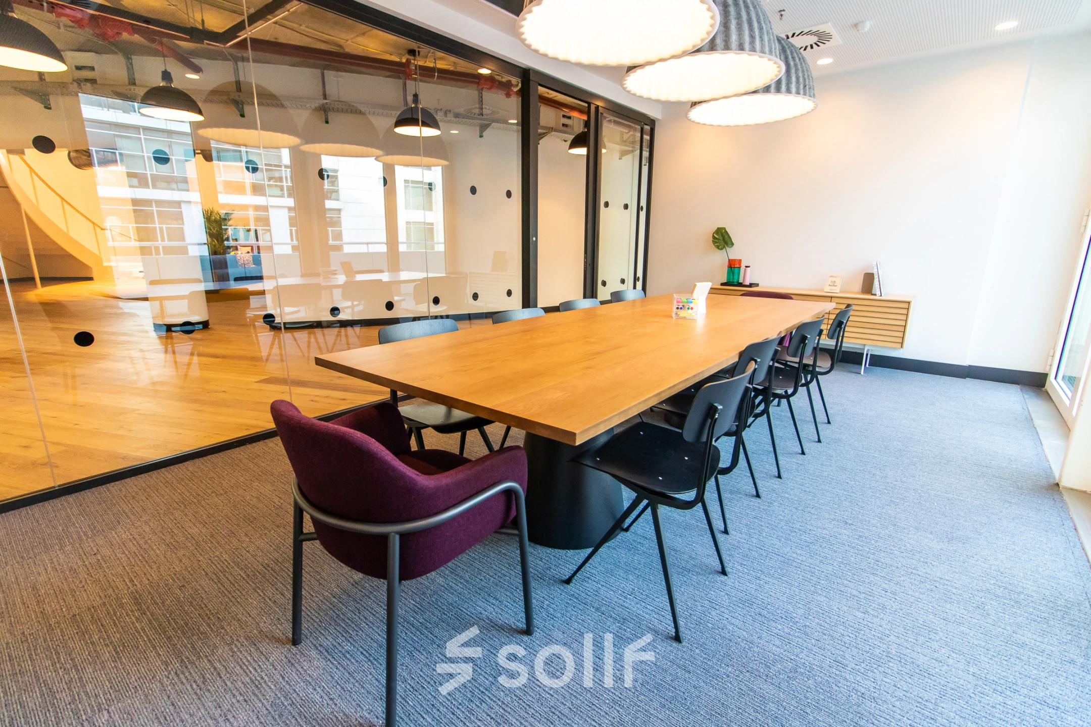 Spacious office to rent at Oskar-von-Miller-Ring 20, Munich Maxvorstadt, featuring a modern conference room with a large wooden table, black chairs, and decorative lighting, perfect for office space rental.