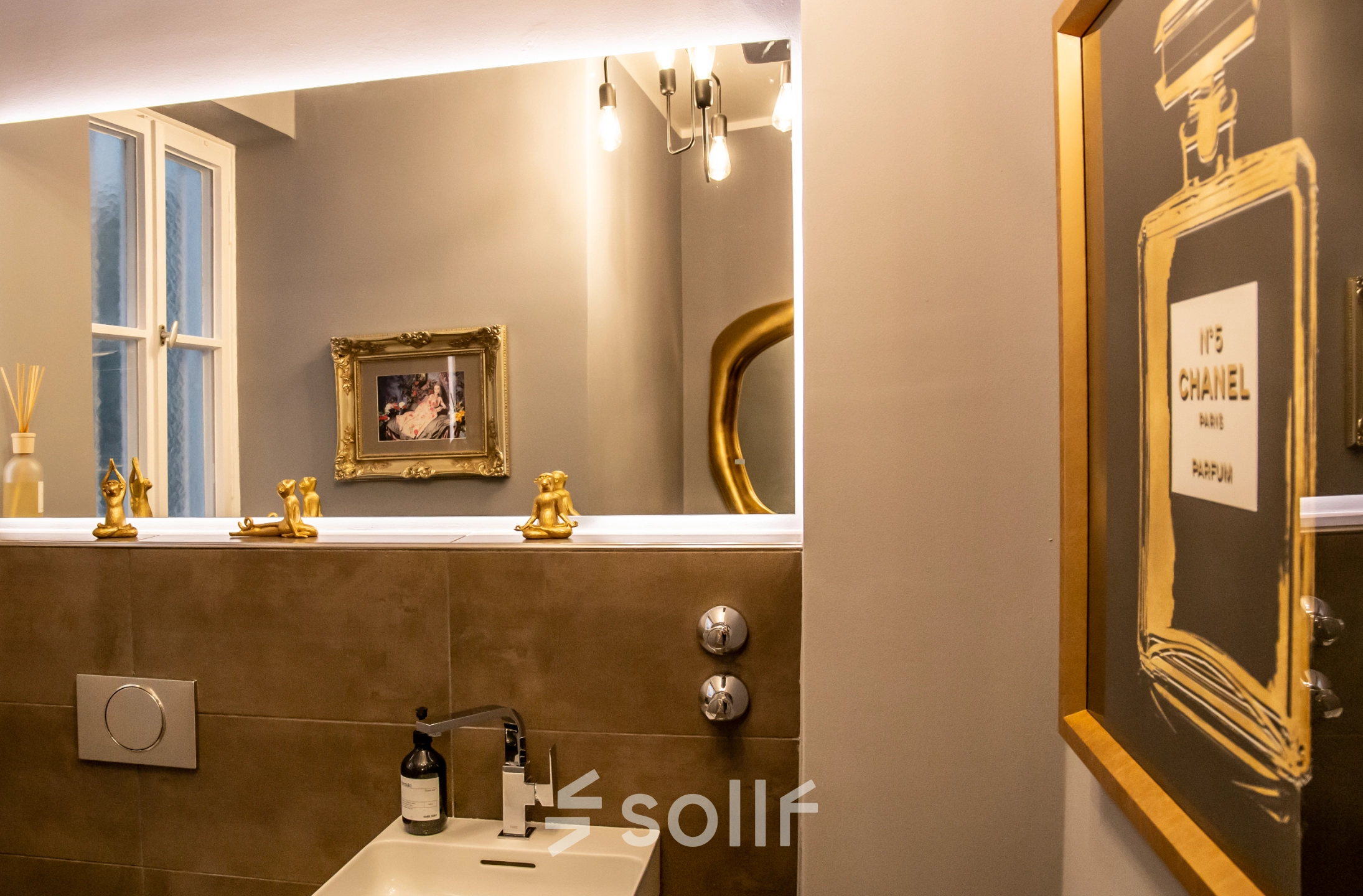 Stylish restroom interior at Marienplatz 17, featuring elegant decor with framed artwork and modern lighting. Ideal for those seeking office space rental with sophisticated amenities.