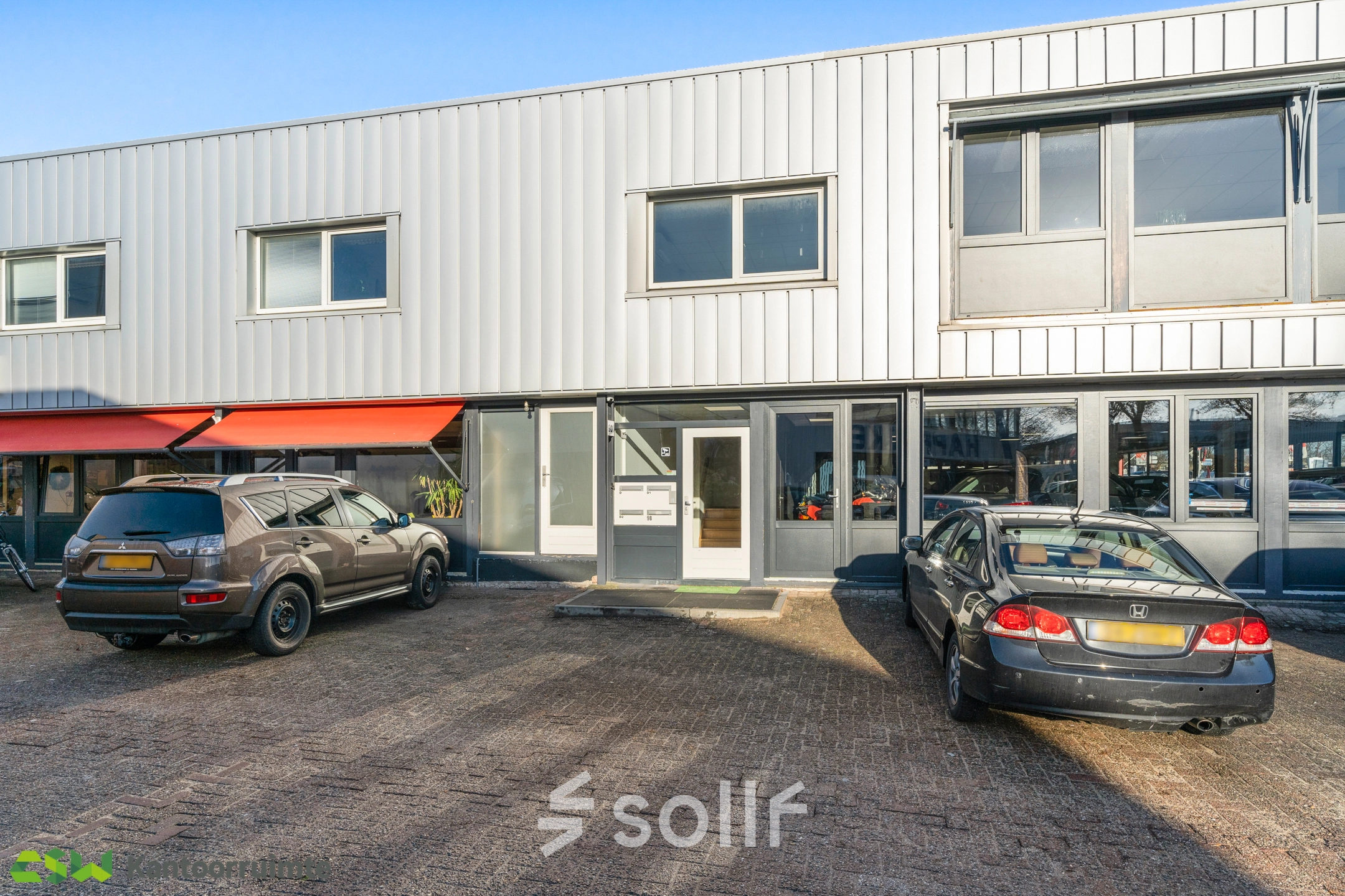 Exterior view of office building at Nijverheidsweg 9B, Nieuwegein, showcasing parking for potential office space rental.