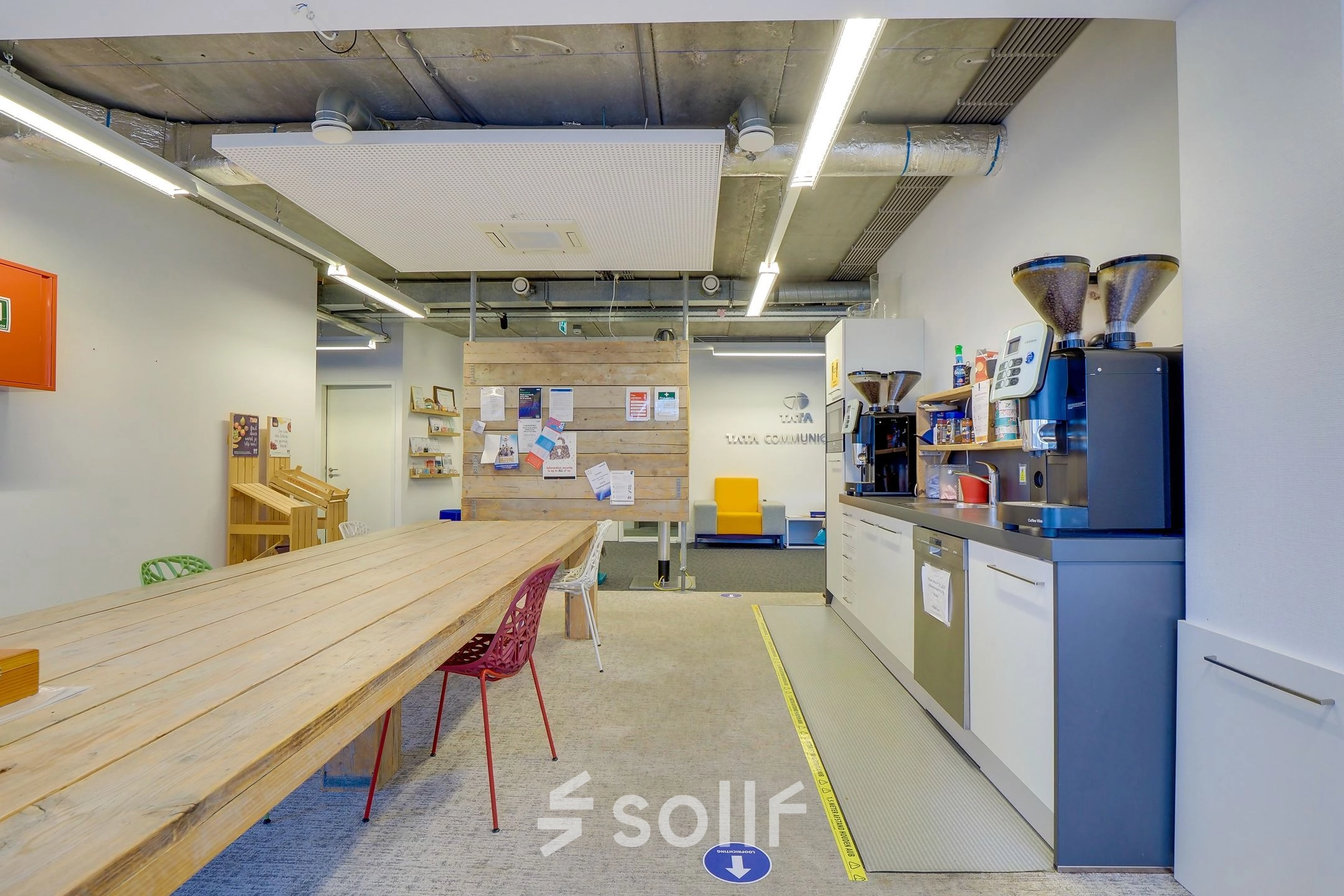 Interior workspace at Zoomstede 19, Nieuwegein features a long wooden table, coffee machines, and bulletin boards, perfect for creative brainstorming. Ideal for office space rental.