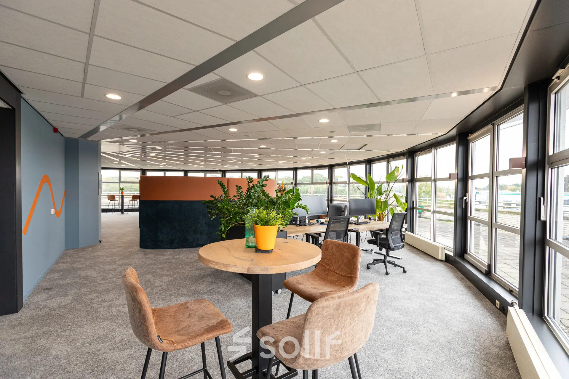 Bright, furnished office space at Patroonstraat 13, Nijkerk, ideal for rent. Open floor plan with modern decor and large windows.