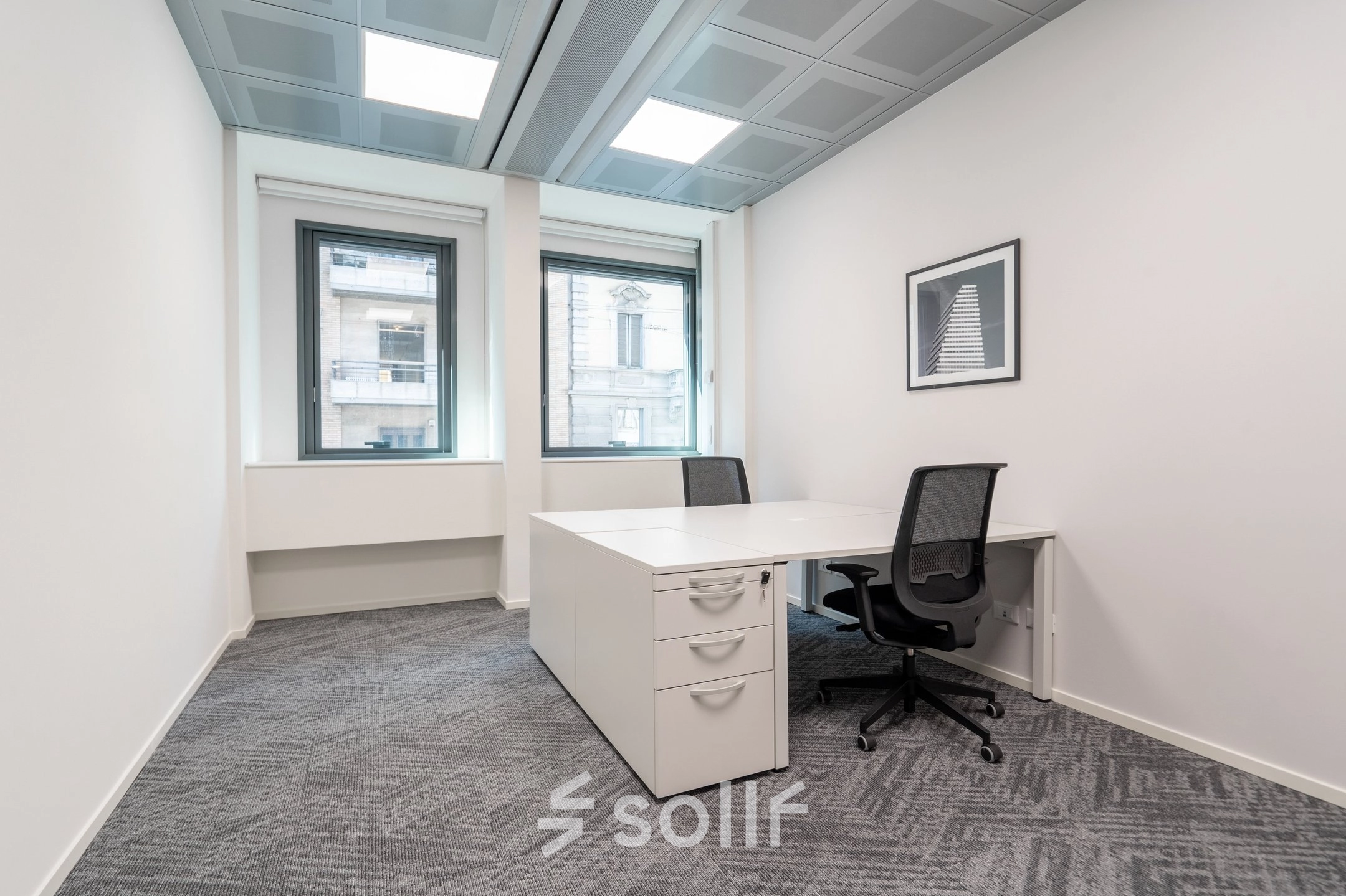 Modern office space rental at Oranjesingel 51, Nijmegen, featuring two desks, chairs, and natural light from large windows.