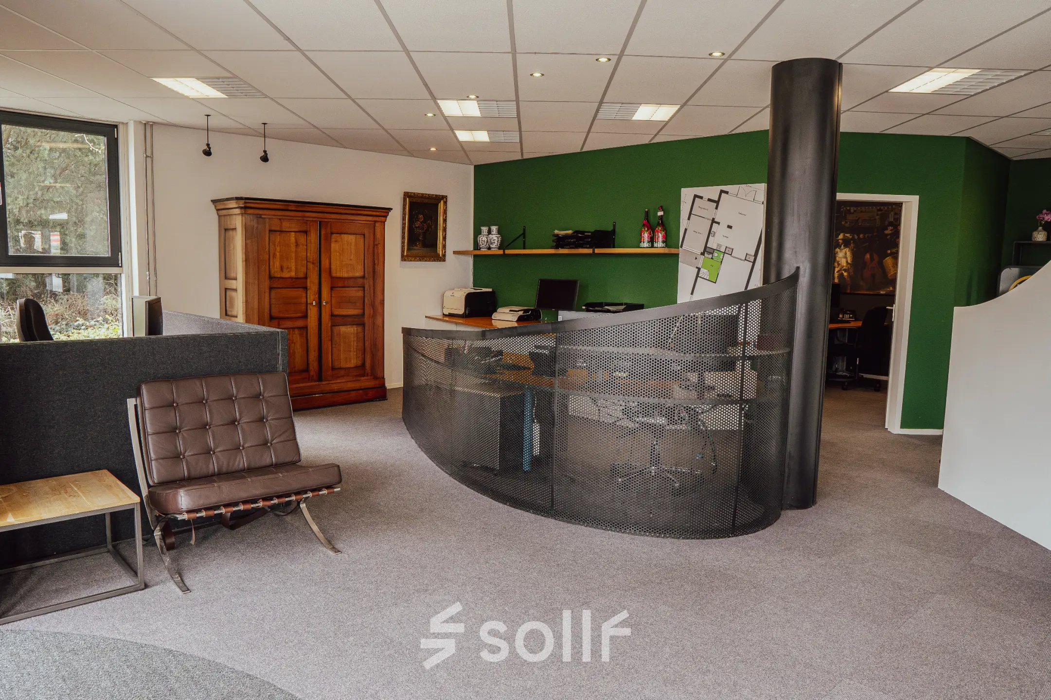 Furnished workspaces with a modern reception desk, green feature wall, and a blend of classic and contemporary furnishings at Abdis van Thornstraat 74, ideal for office space rental.