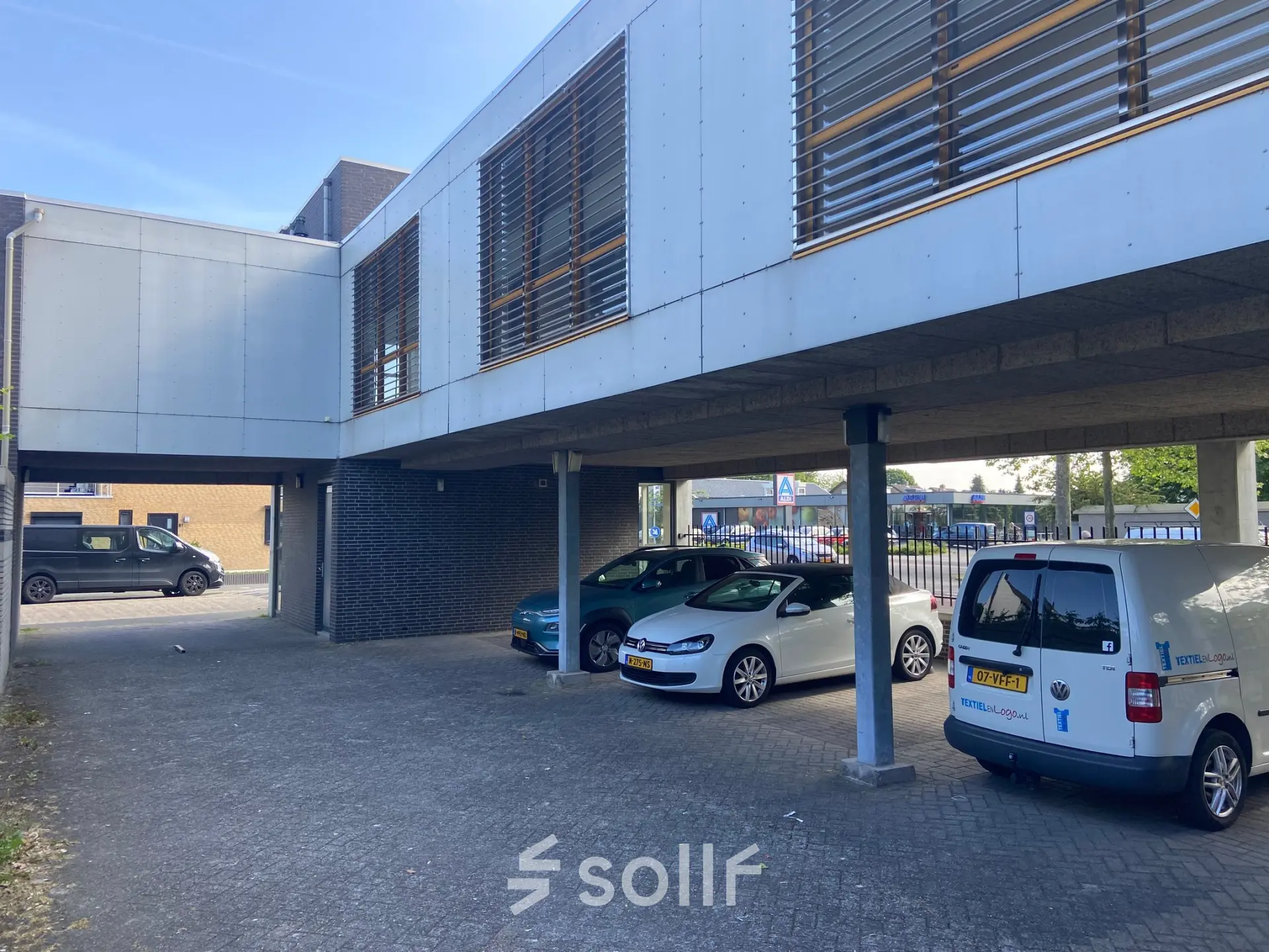 Exterior view of office building at Abdis van Thornstraat 74, Oosterhout Nb, with parking area partially shaded by modern overhang.