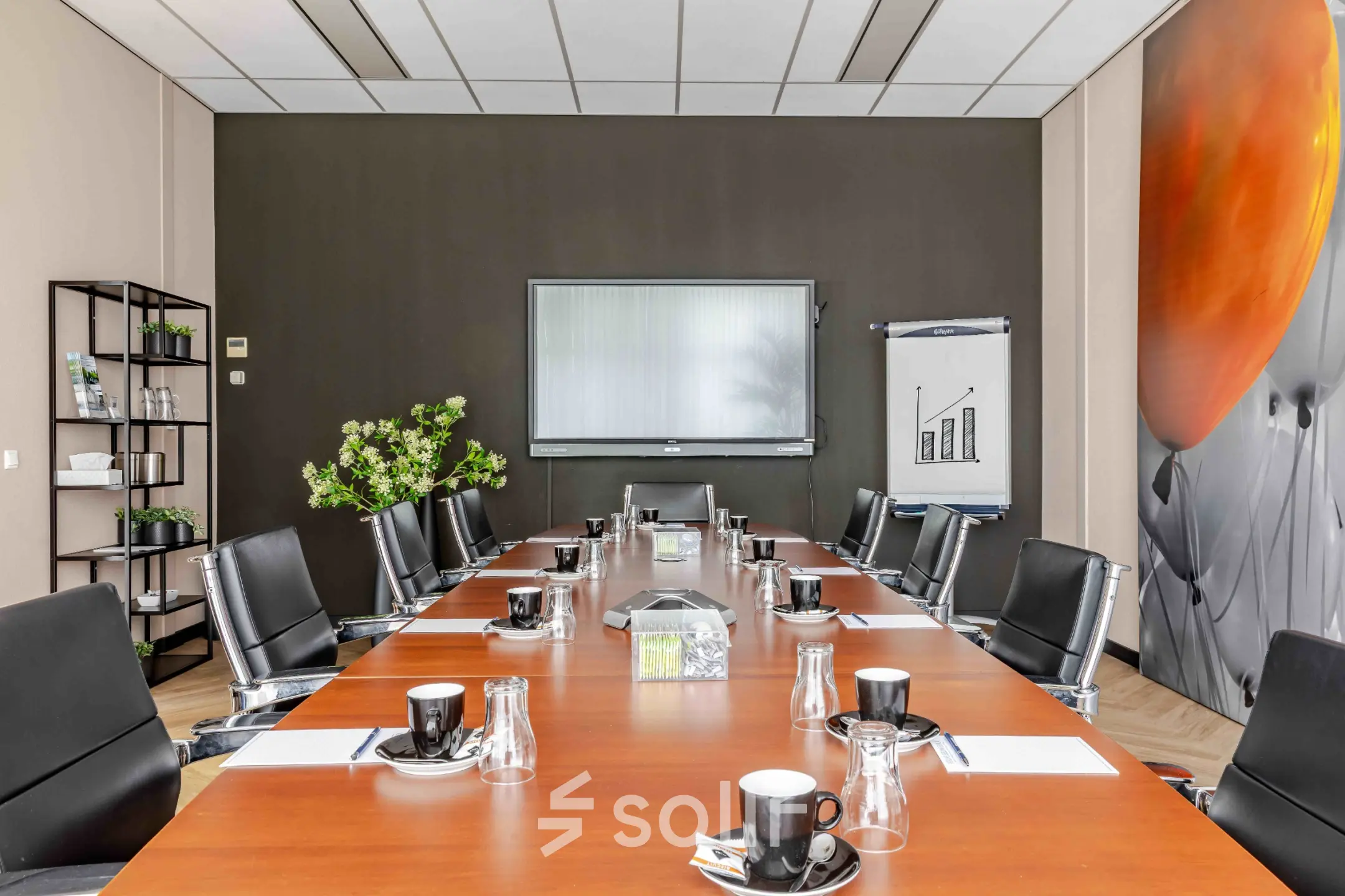 Spacious conference room for office space rental at Leeghwaterstraat 25, featuring a large wooden table and modern black chairs.