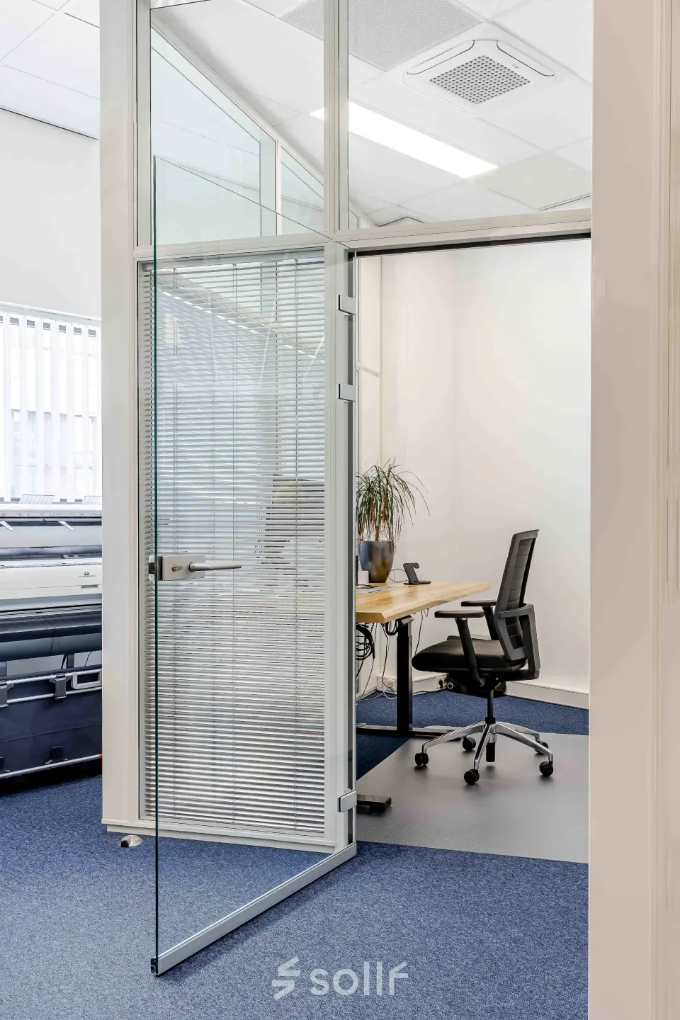 Modern office space at Leeghwaterstraat 25, Reeuwijk, featuring a desk and office chair with natural light pouring through large windows.
