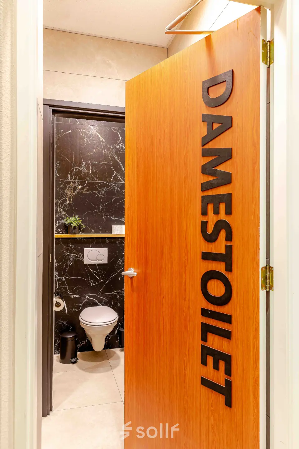 Interior restroom with wooden door labeled 'DAMESTOILET' at Leeghwaterstraat 25 office space to rent in Reeuwijk.