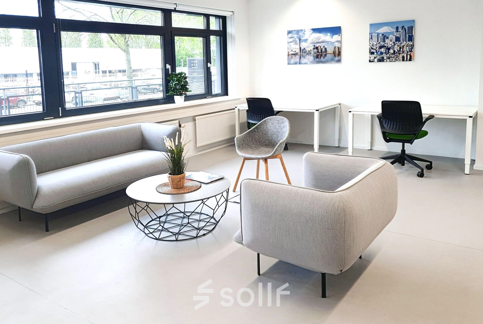 Spacious office at Einsteinlaan 28, Rijswijk features modern furnishings, including sofas and individual desks, ideal for office space rental. Large windows provide natural light.