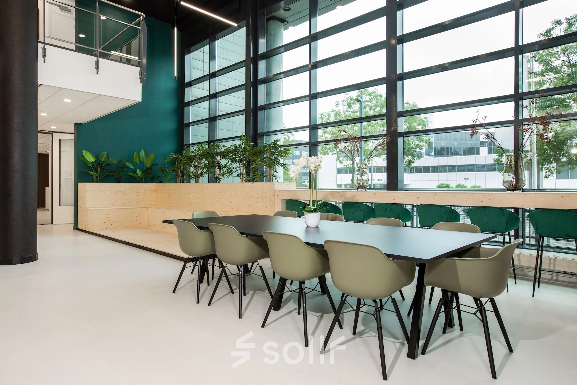 Modern office space for rent at Einsteinlaan 28 in Rijswijk, featuring a spacious furnished interior with a long conference table and large windows letting in natural light.