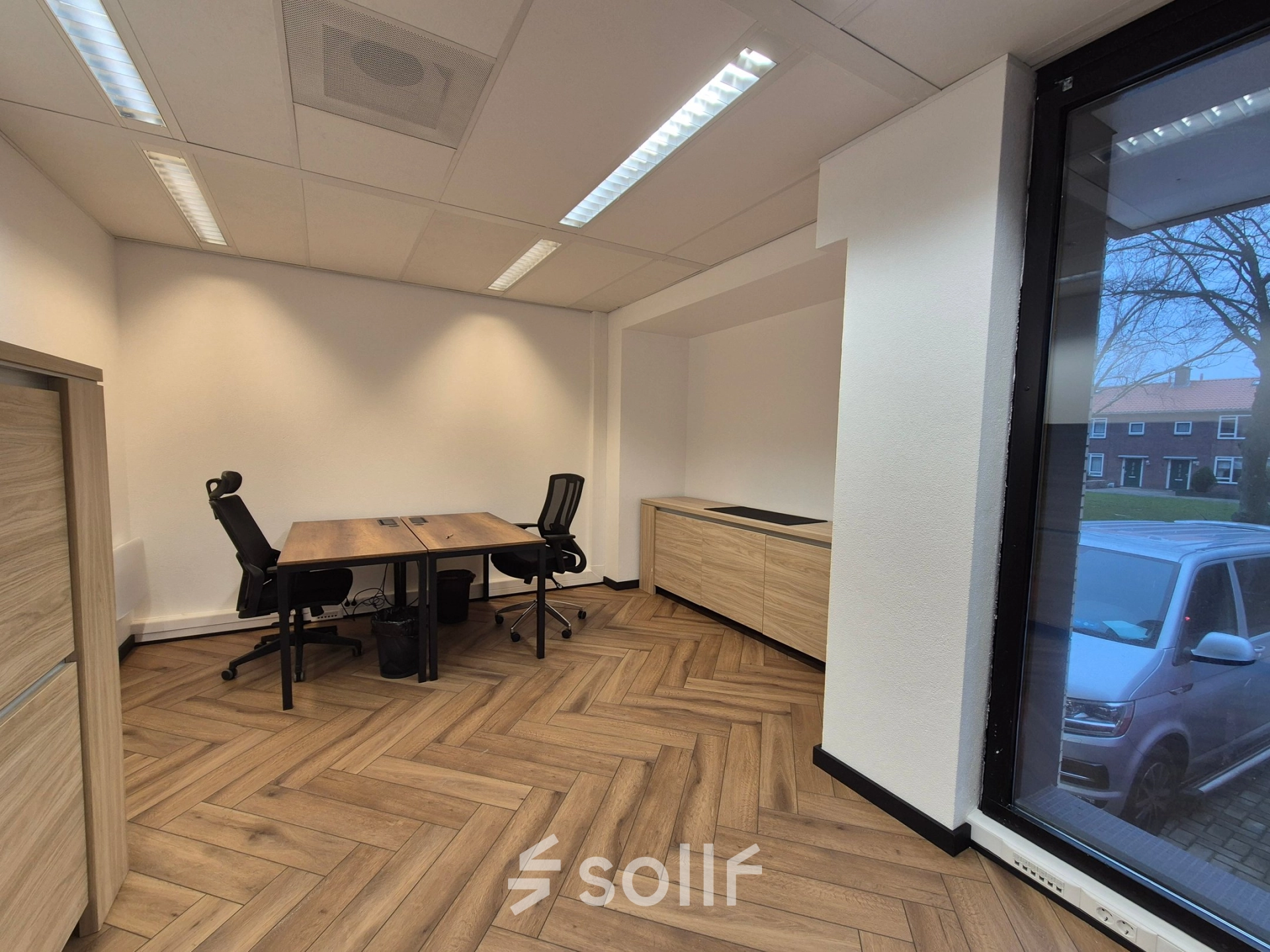 Modern office space at JC van Markenlaan 3, Rijswijk featuring wood flooring, large window, and two desks with chairs for rent office space.