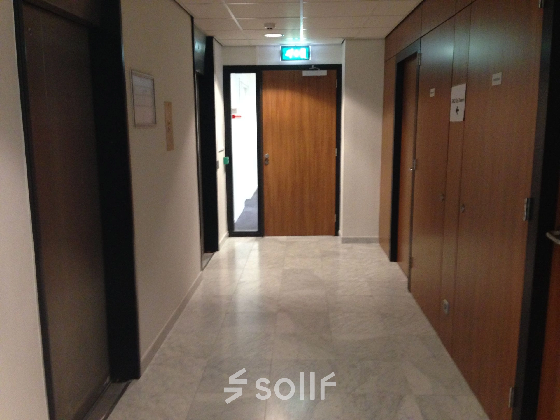 View of a hallway at JC van Markenlaan 3, Rijswijk, suitable for office space rental, featuring clean walls and tiled flooring.