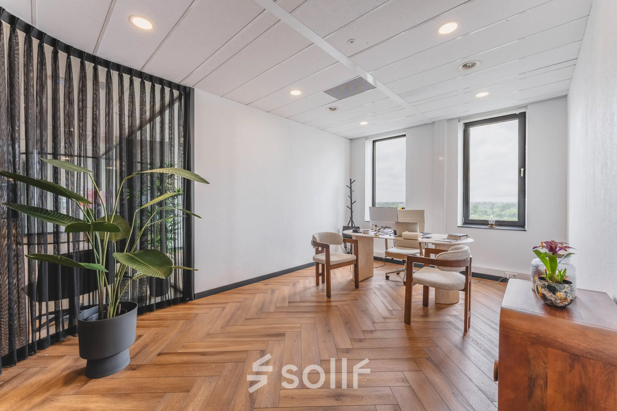 Bright office space at Laan van Zuid Hoorn 70, Rijswijk, featuring wooden flooring, a large plant, and a desk with chairs ready for meetings. Ideal for rent office space needs.