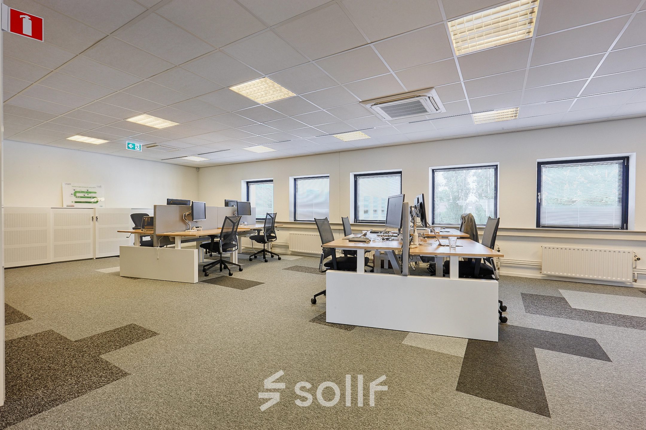 Office space at Patrijsweg 62, Rijswijk, featuring rows of desks and chairs under a grid ceiling, ideal for office space rental.