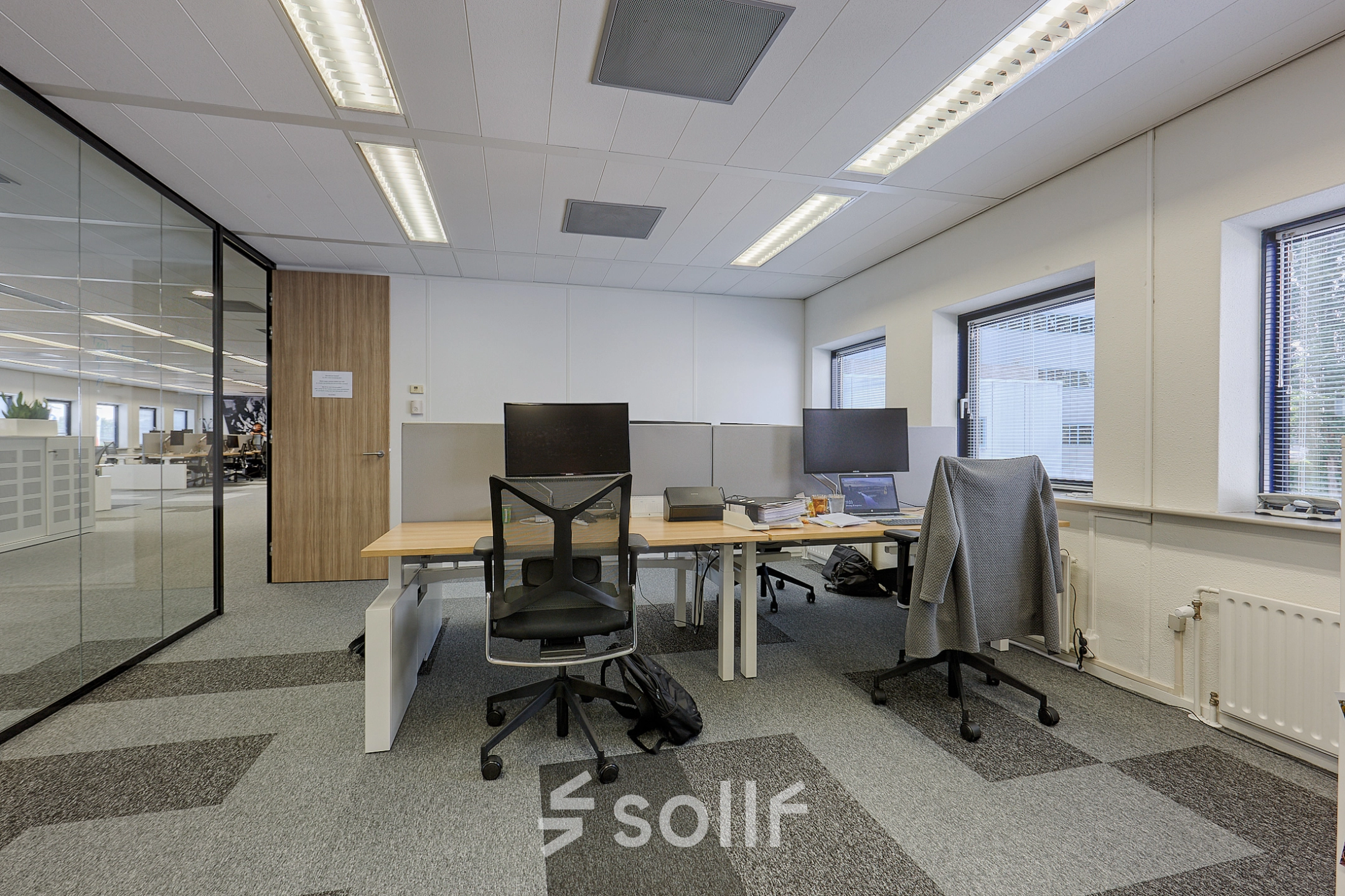 Interior view of a furnished office space with workstations at Patrijsweg 62, ideal for rent office space in Rijswijk. Equipped with desks, chairs, and computers, ready for business activities.