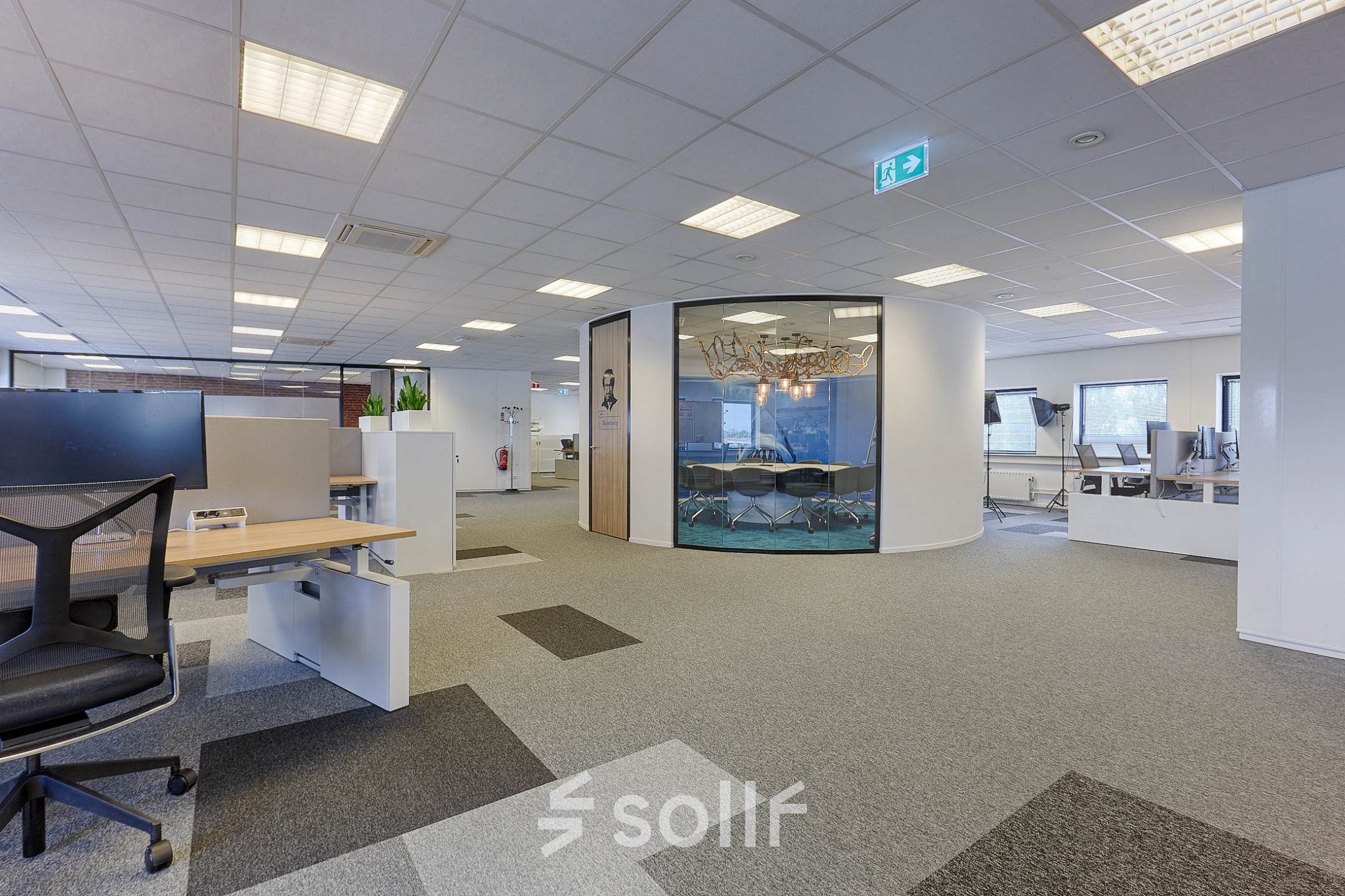 Modern office space for rent at Patrijsweg 62, Rijswijk, featuring open floorplan with workstations and a glass-walled conference room.