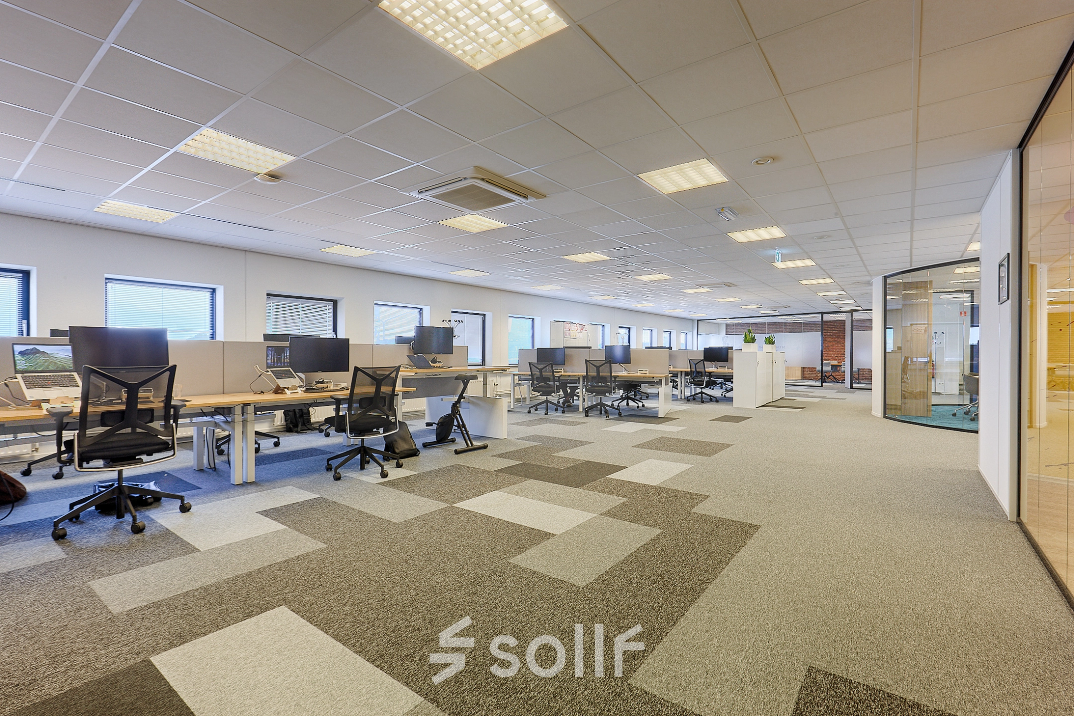Spacious office to rent at Patrijsweg 62, Rijswijk, featuring multiple desks and chairs, ideal for collaborative work. Bright lighting and large windows enhance the office space rental appeal.