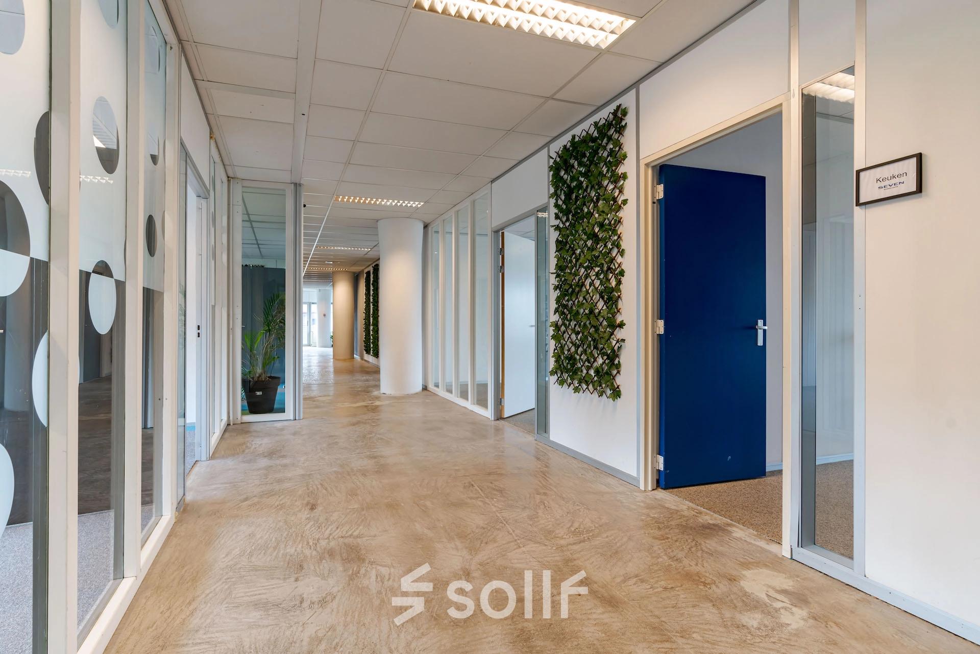 Hallway with wooden floor and glass-walled rooms in an office for rent at Polakweg 7, Rijswijk.