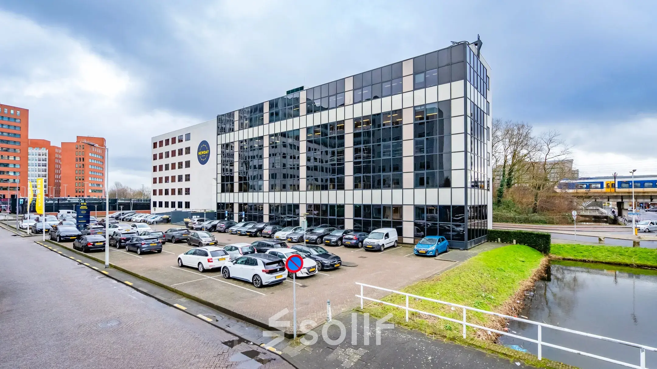 Exterior view of an office building at Marten Meesweg 8-10, Rotterdam Alexander, showcasing available office space rental with a visible parking area.