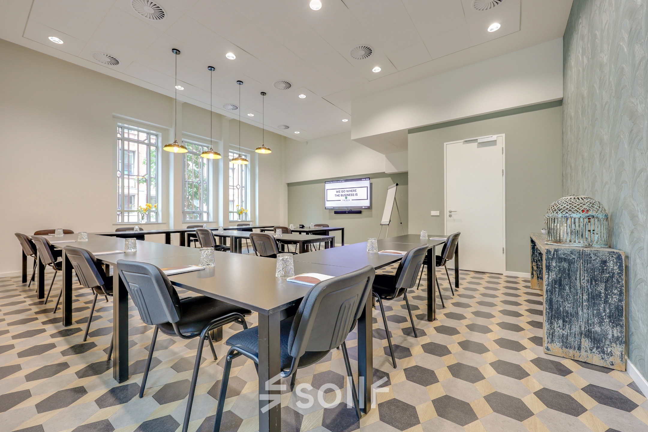 Modern office space rental at Blaak 34, Rotterdam Center, featuring a well-lit conference room with tables, chairs, and a presentation screen.