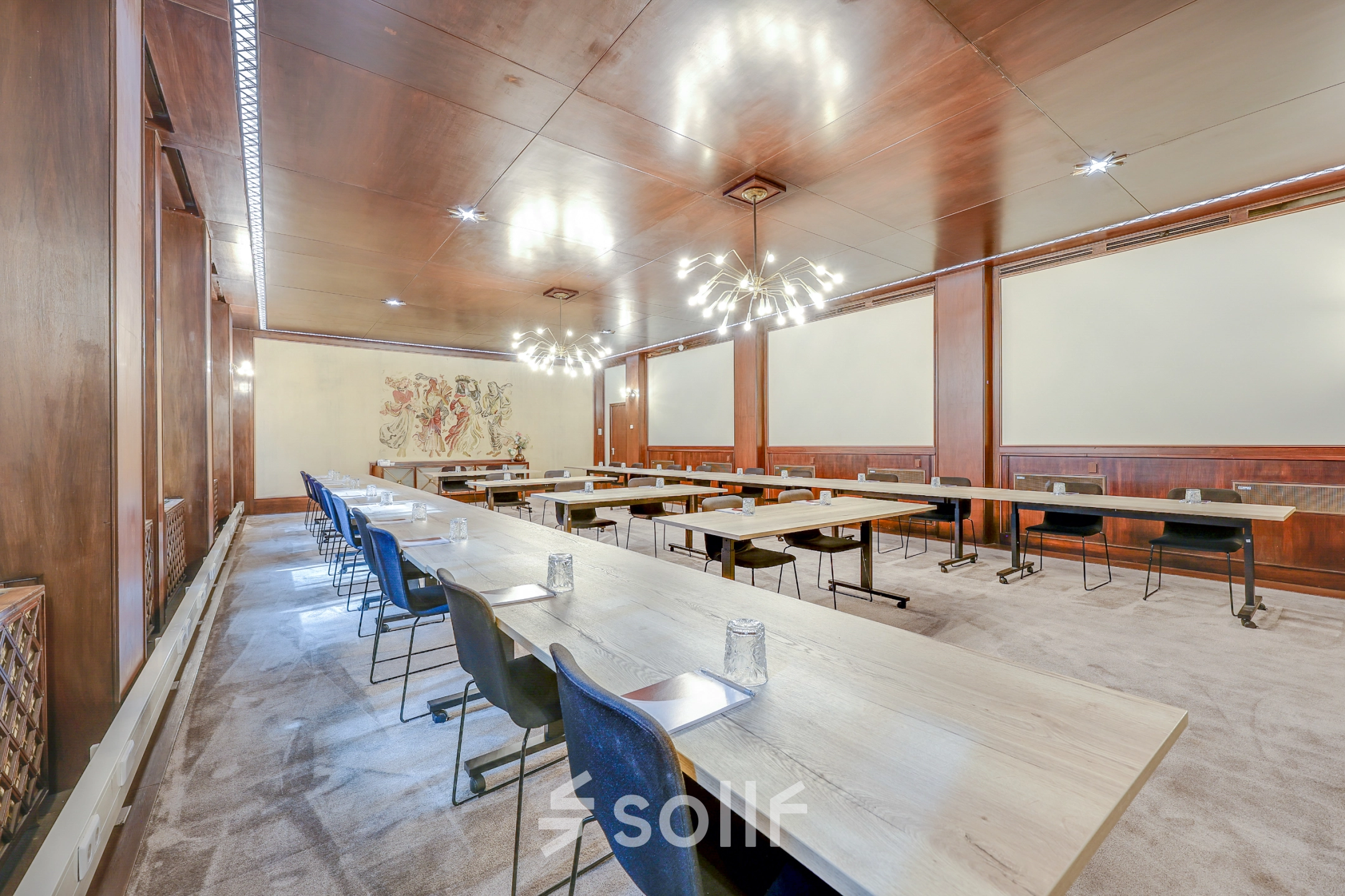 Spacious conference room in Rotterdam Center, Blaak 34, available for office space rental. Tastefully furnished with modern lighting, long tables, and chairs, perfect for meetings.