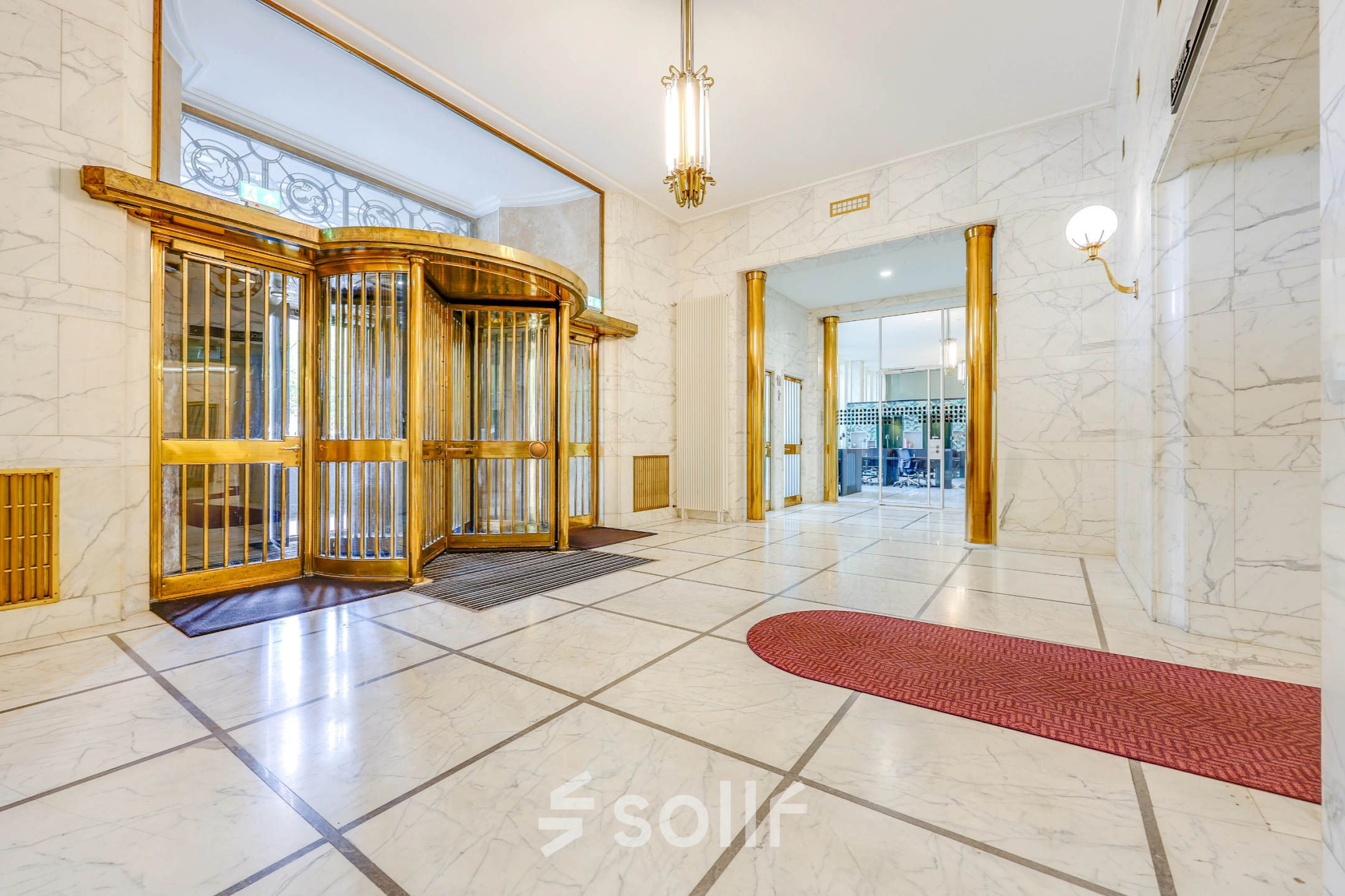 Spacious entrance area of an office to rent at Blaak 34, Rotterdam Center, featuring elegant marble detailing and a vintage revolving door. Ideal for office space rental with welcoming aesthetics.