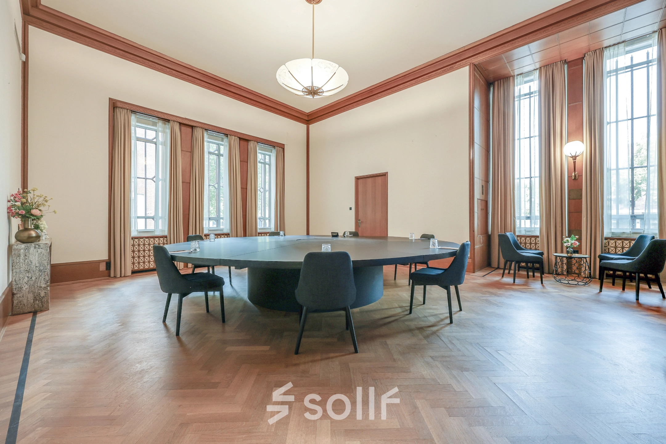 Spacious office to rent at Blaak 34 in Rotterdam Center, featuring a large table surrounded by chairs with natural light from tall windows, ideal for office space rental.