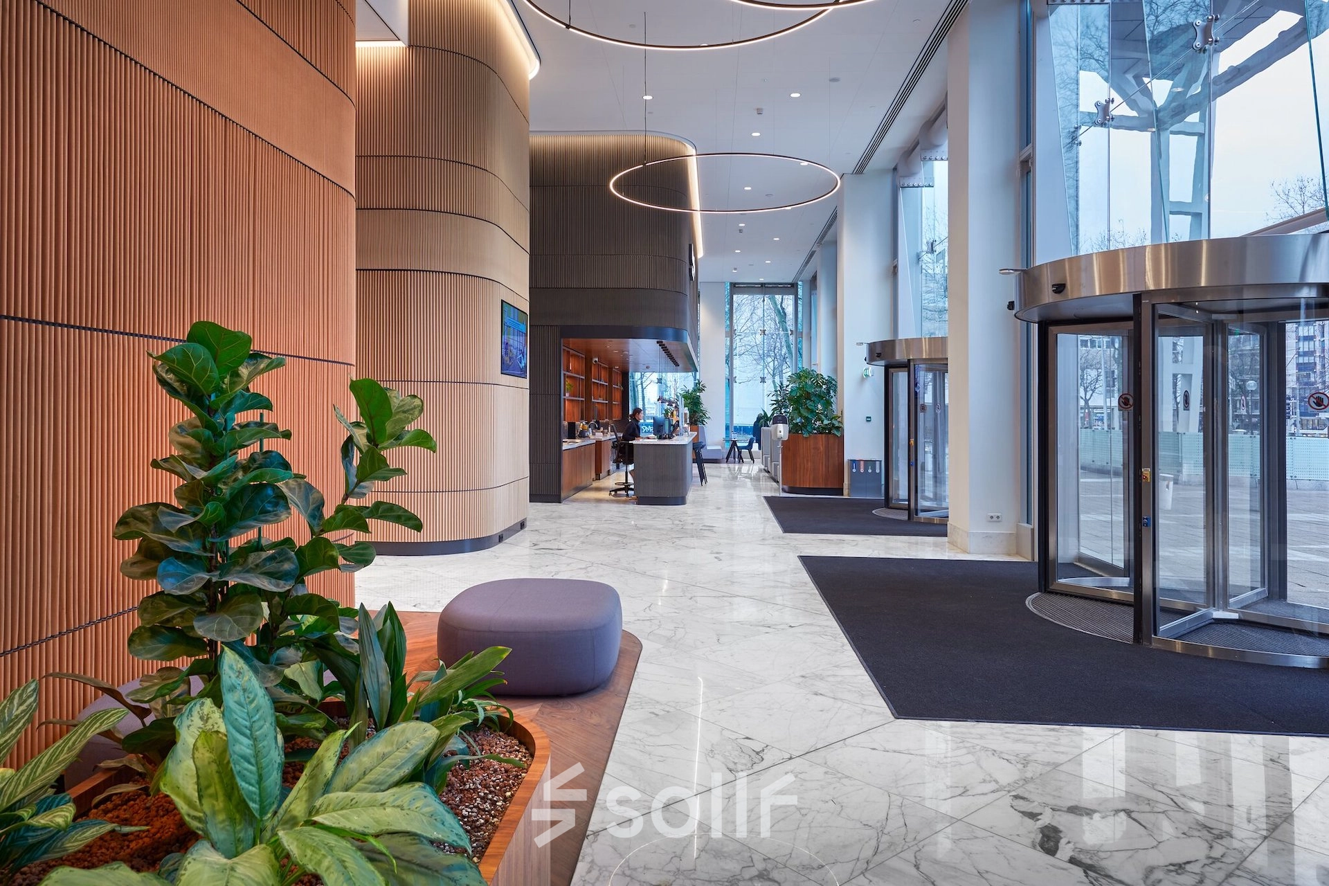 Spacious reception area at Blaak 555, Rotterdam Center, featuring modern decor and plant accents. Ideal for businesses seeking office space rental.