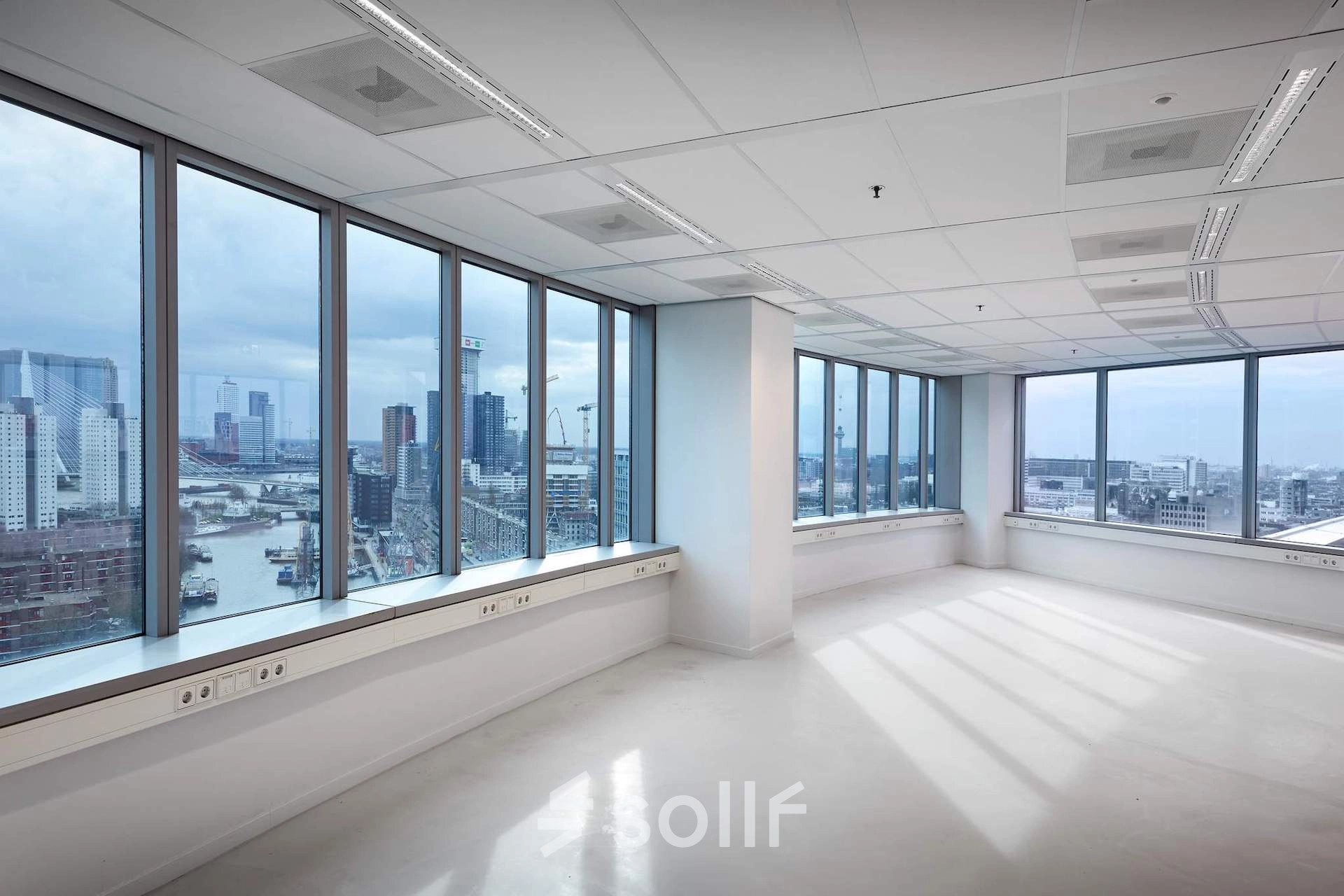 Bright, unfurnished office space at Blaak 555 in Rotterdam Center, featuring large windows with city views, ideal for office space rental.