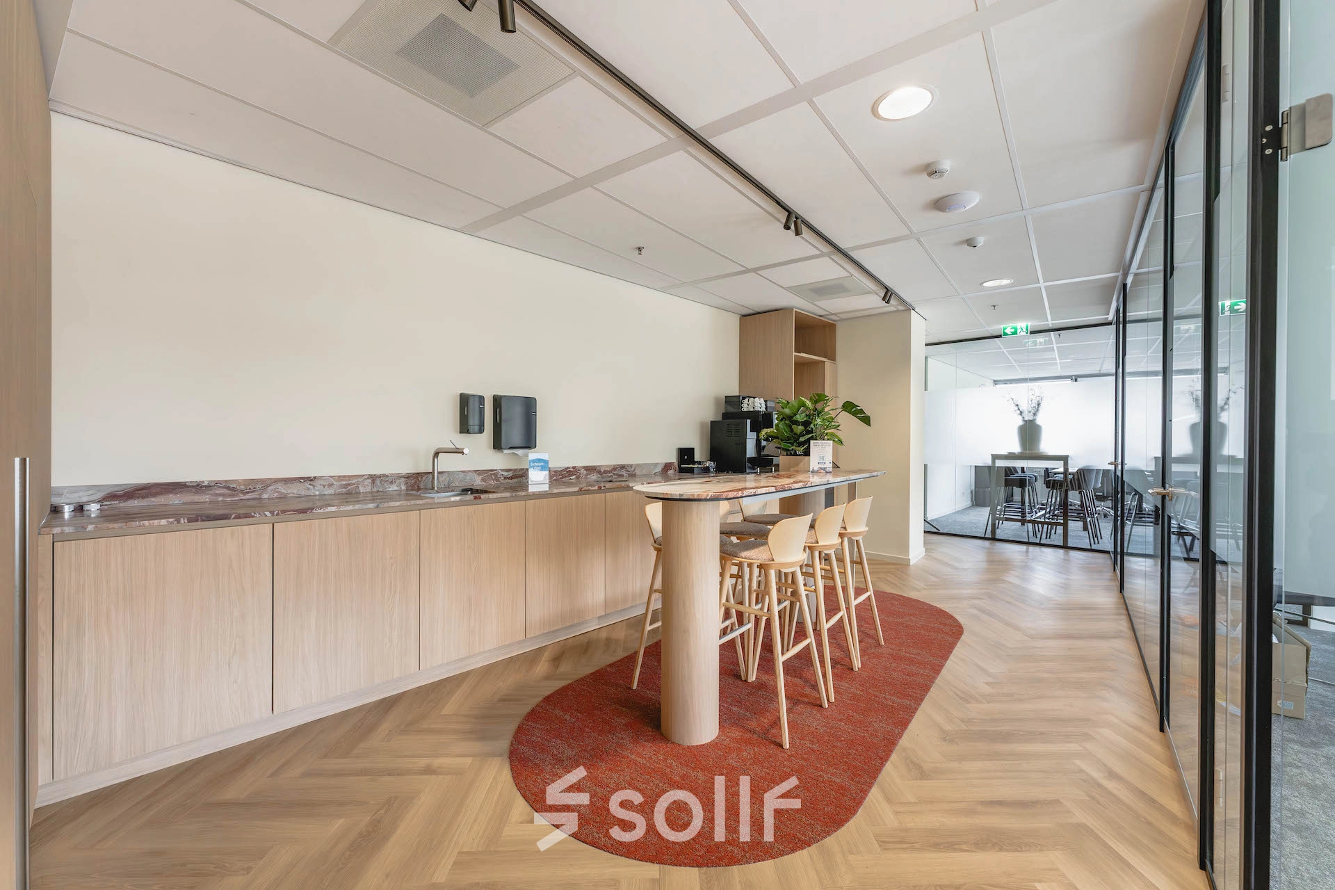 Bright office space at Blaak 555, Rotterdam Center, featuring an inviting lounge area with modern furniture and sleek design, ideal for office space rental.