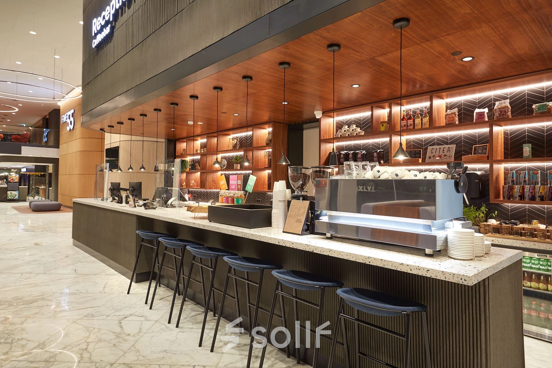 Modern reception area at Blaak 555 in Rotterdam Center with a sleek counter and stylish lighting, ideal for office space rental.
