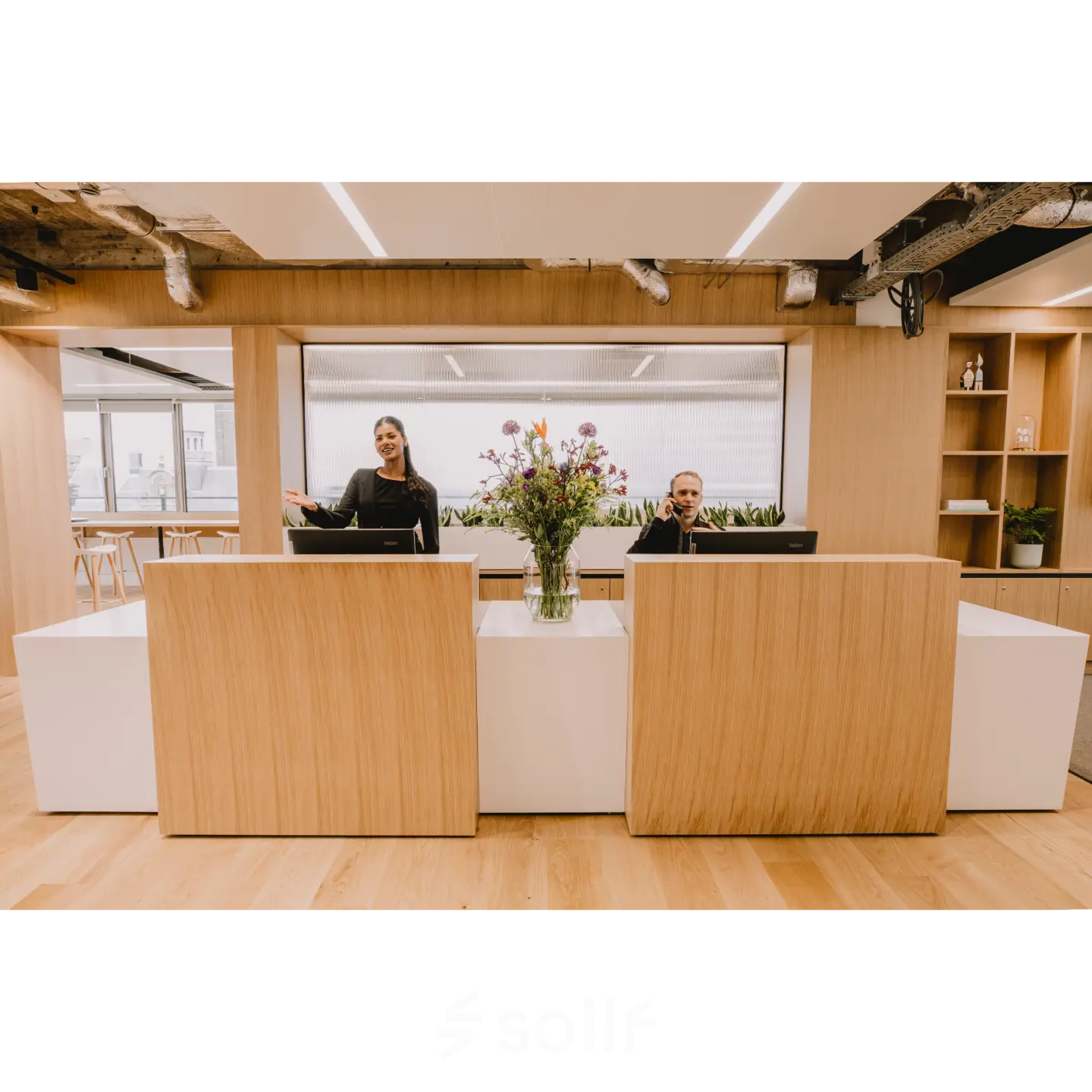 Modern office reception area at Coolsingel 65, Rotterdam Center, with two people at the desk, ideal for office space rental inquiries.