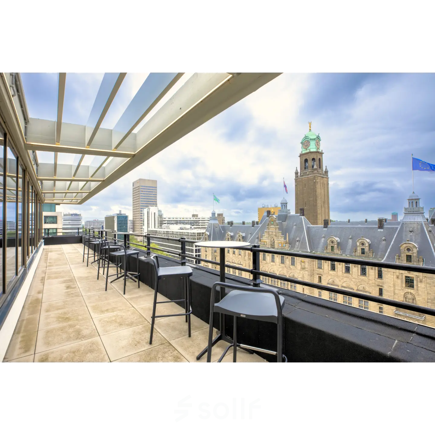 A scenic balcony view from an office to rent at Coolsingel 65, showcasing Rotterdam's skyline with tables and chairs arranged for a pleasant break or informal meeting.