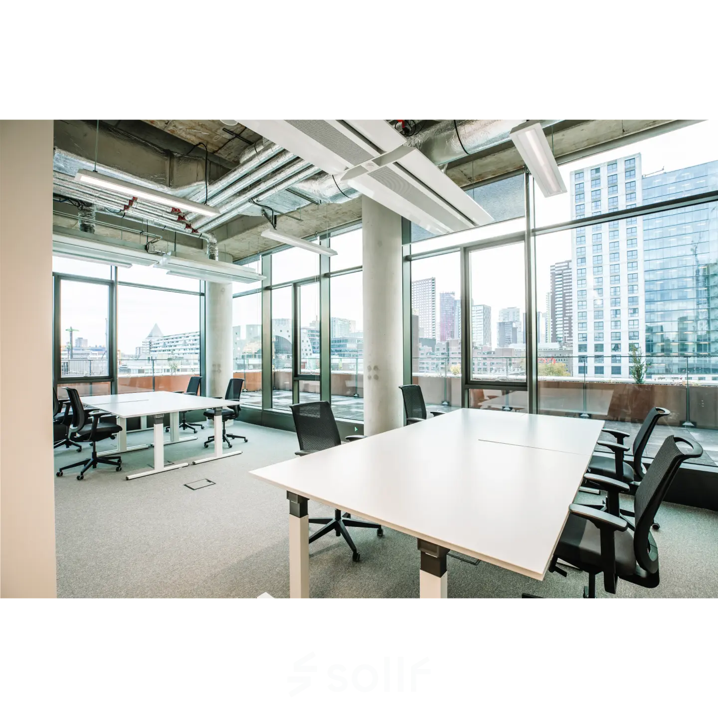 Spacious office to rent at Hoogstraat 185, Rotterdam Center, featuring large windows, multiple desks, and ergonomic chairs. Ideal office space rental with city views.