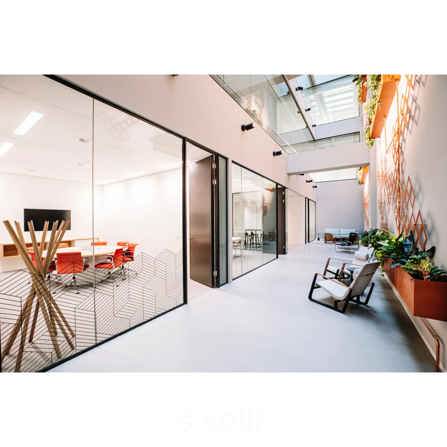 Modern office space for rent in Rotterdam Center with glass-walled conference rooms and stylish seating area, located at Hoogstraat 185.