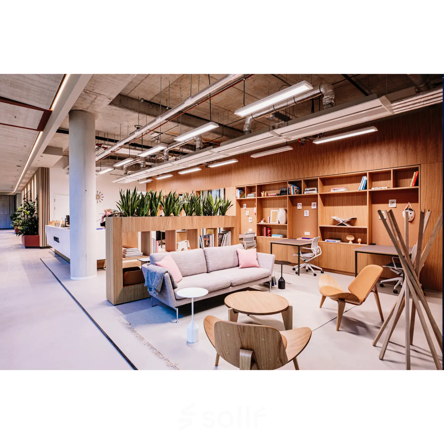 Modern furnished office space for rent at Hoogstraat 185, Rotterdam Center, featuring stylish seating and workspaces with plants and shelves for a comfortable office space rental experience.