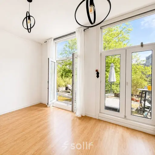 Bright office space at Mauritsweg 33 A01 in Rotterdam Center, featuring large windows and hardwood flooring, available for office space rental.