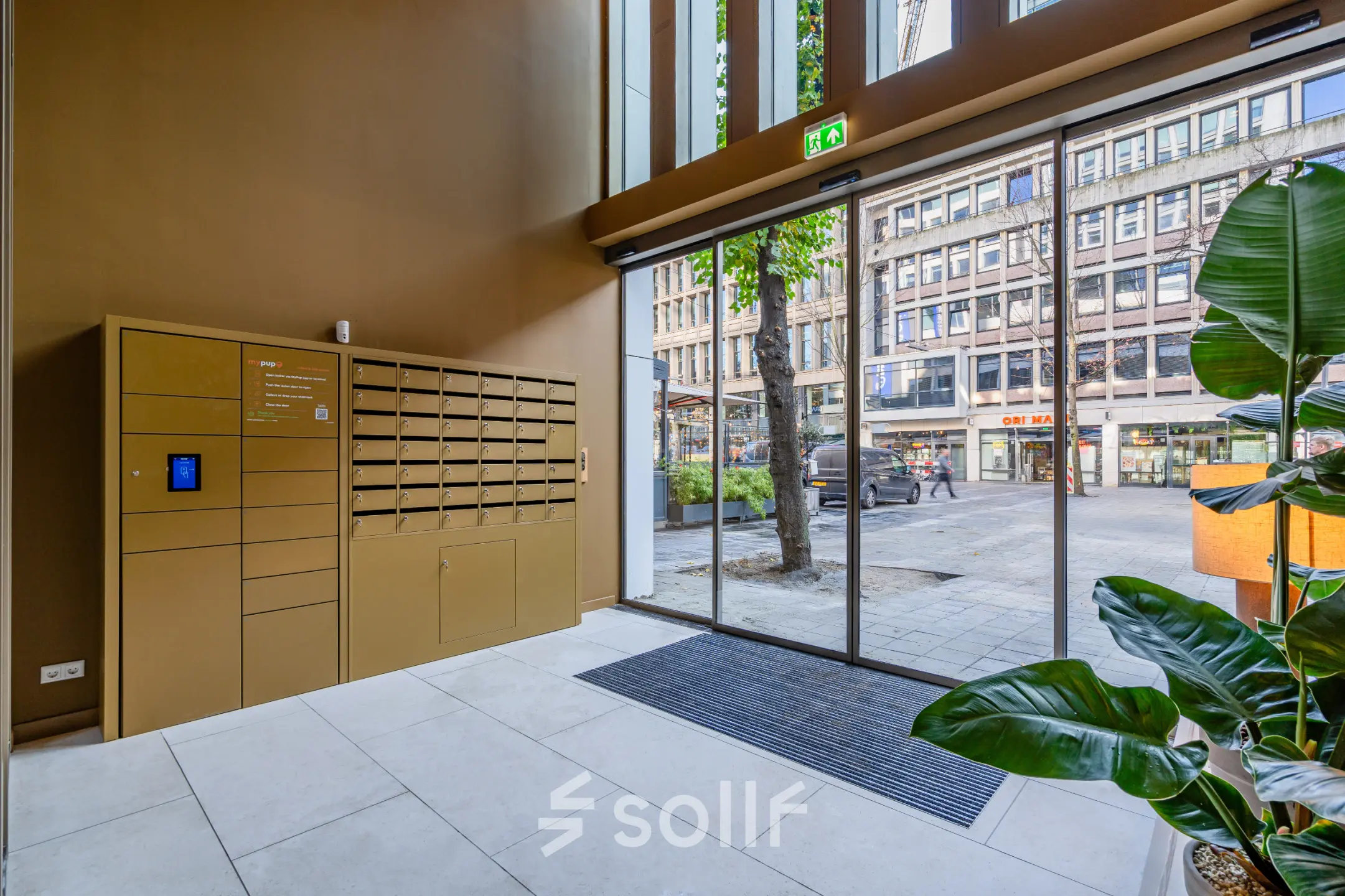 Bright entrance area with large glass doors at office space rental location Stadhuisplein 9-23, Rotterdam Center.